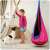 Child playing with a dog near a NeoSport single hanging swing, pink