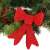 Red glitter Christmas tree bow, Springos brand, on a Christmas wreath