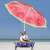 Woman relaxing under Springos watermelon beach umbrella on the beach