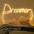 Springos LED string lights spelling out 'Dreamer' above a bed