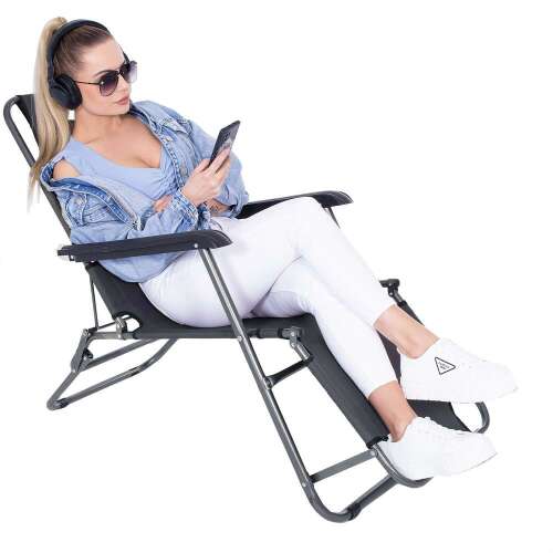 Woman sitting in a Springos dark gray folding lounge chair, using her phone