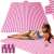 Pink striped beach blanket with woman laying on it