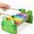 Child's hands playing a frog-shaped wooden xylophone with colorful metal bars