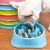 Dog eating from blue slow feeder bowl with stacked bowls in background