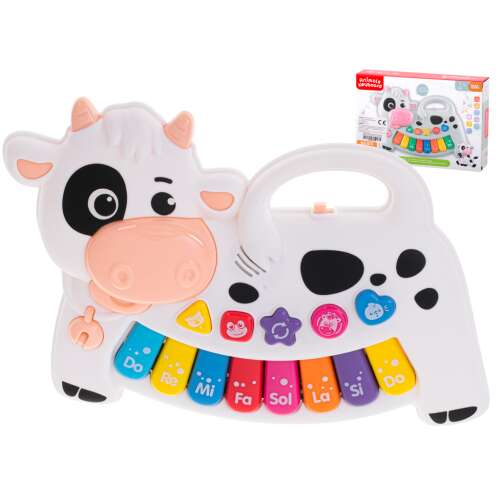 White and black cow shaped musical toy with piano keys and animal sound buttons