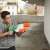 Boy playing with Nerf Super Soaker Hydro Frenzy water blaster, green and orange
