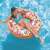 Woman relaxing on Intex Donut Sprinkle inflatable swim ring in pool