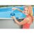 Woman adding chlorine tablet to Intex floating chemical dispenser in pool