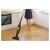 Woman using Sencor SVC 0741YL cordless stick vacuum cleaner on hardwood floor