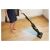 Woman using Sencor SVC 0741YL cordless stick vacuum cleaner on hardwood floor