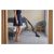 Woman using Sencor SVC 0741YL cordless stick vacuum cleaner on carpet