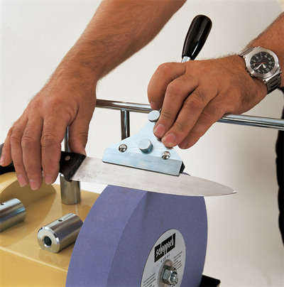 Scheppach jig for sharpening long knives, shown in use on a Scheppach grinder