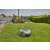 Gardena SILENO life 750 robot lawnmower mowing a lawn with a person relaxing in the background