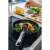 Fiskars Functional Form spatula with silicone edge, black and orange, in use for cooking salmon