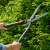 Gardena EnergyCut hedge shears, being used to trim a hedge, person holding the shears