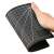 Hand holding a self-healing cutting mat, A5 size, black, with grid lines and angle guides