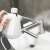 Bewello BW2003 handheld steam cleaner being used to clean a faucet