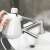 Handheld steam cleaner being used to clean a faucet
