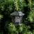 Solar powered flame light, black lantern with decorative cutouts, 12 LED lights, for outdoor use, hanging on tree branch