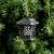 Solar powered flame light, black lantern with decorative cutouts, 12 LED lights, for outdoor use, hanging on tree branch