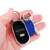 Key Finder keychain with LED light and whistle, in hand