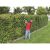 Man using Einhell GE-HC 18 Li T cordless pole hedge trimmer to trim hedge