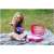 Child playing with a pink toy kitchen playset in a suitcase