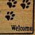 Close-up of Kókuszszőnyeg doormat with paw prints and 'Welcome' message