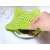 Green silicone sink drain filter being placed over a sink drain, star shaped, for catching food scraps and hair