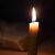 O singură lumânare conică aprinsă în întuneric