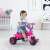 Toddler riding a pink unicorn trike in a room