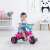 Toddler riding a pink unicorn trike in a room