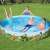 Kids playing in Bestway Dinosaur Kids Pool, 244x46 cm, round, blue, green, white