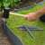 Nature grey plastic garden edging stakes being used to install garden edging