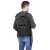 Springos black tactical backpack worn by a man, rear view