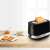 Bosch TAT6A513 2-slice toaster, black with stainless steel accents, showing toasted bread