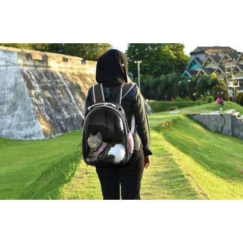 Person wearing the black and white pet carrier backpack with clear bubble, walking with a cat inside