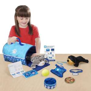 Melissa & Doug Tote & Tour Pet Travel Play Set, ein Mädchen spielt mit dem Set und legt eine Plüschkatze in den Transportbehälter - Melissa & Doug