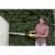 Woman using Karcher HGE 18V-50 cordless hedge trimmer to trim a hedge near a wall
