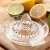 Judge glass citrus press, clear, with handles, on wooden surface with lemons and limes