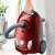 Electrolux EEG43WR bagged vacuum cleaner, red, being carried