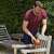 Man using Black+Decker BEW210-QS 120mm random orbit sander to sand a wooden chair