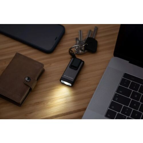 Ledlenser K6R kulcstartó lámpa egy asztalon kulcsokkal és pénztárcával