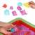 Hands playing with kinetic sand in inflatable sandbox with molds