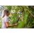 Жена използва Fiskars L86 SmartFit Телескопична ножица за клони в градината