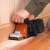 Black+Decker KA88 belt sander in use, sanding wood floor, dust bag
