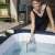 Woman cleaning the inflatable hot tub with the Bestway Lay-Z-Spa scoop