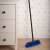 York Partvis 120cm broom with handle, blue bristles, 33x10cm head, leaning against a white dresser