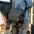 PGYTECH OneGo 6L shoulder bag, obsidian black, man using the bag with a tripod attached