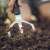 Person using Fiskars Xact™ cultivator to loosen soil in garden